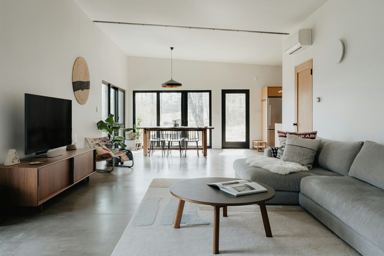 An open-plan living room with a wall-mounted air conditioning unit